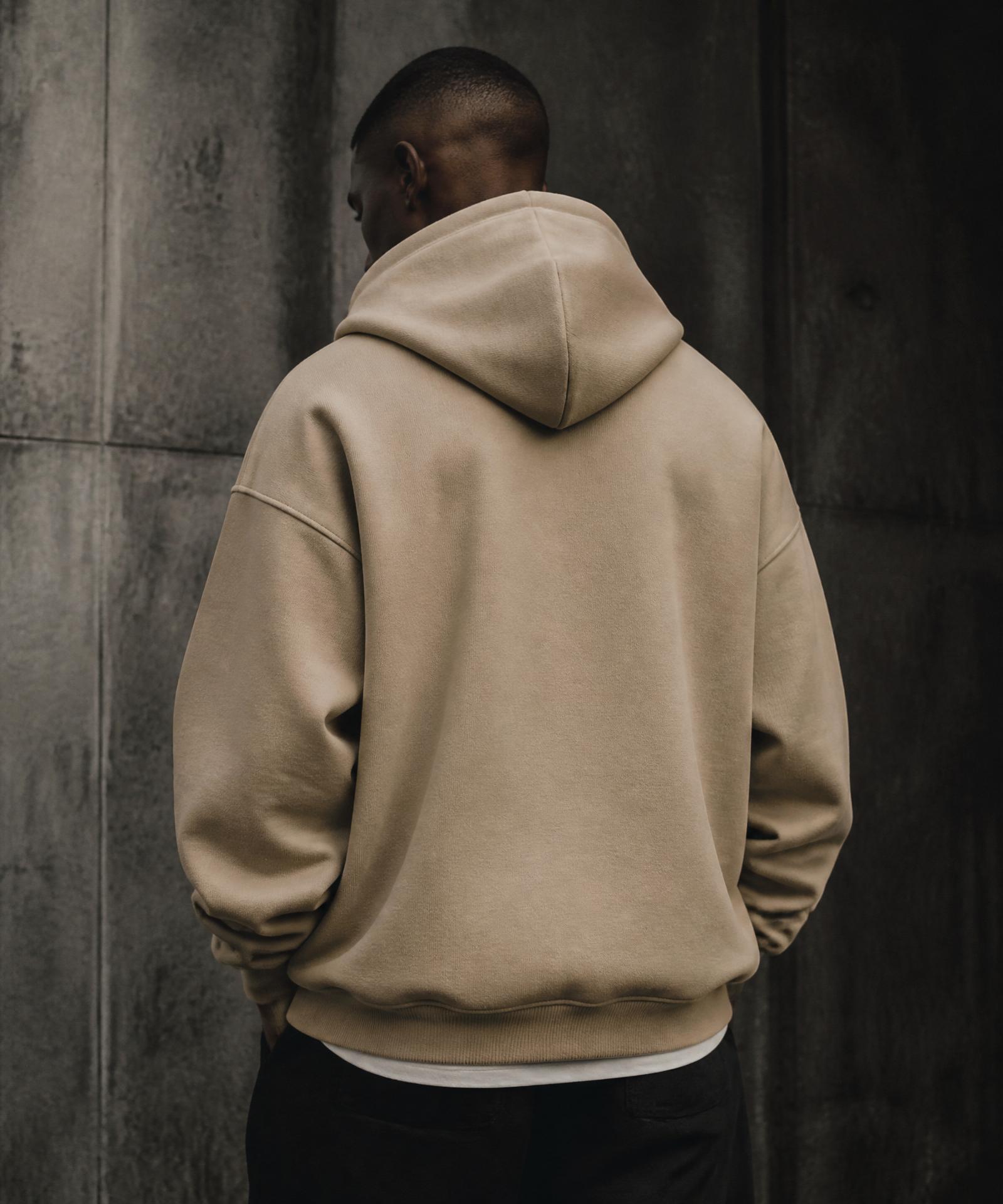 Model wearing the UNYON oversized hoodie against a concrete wall